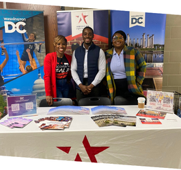 Three Destination DC staff members in front of pop up banners at AEF branded table 