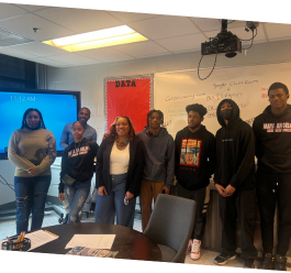 Students at Maya Angelou Charter High School in front of screen and whiteboard 
